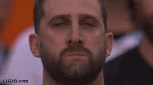A Man With A Beard Is Crying With His Eyes Closed In A Crowd Of People . GIF