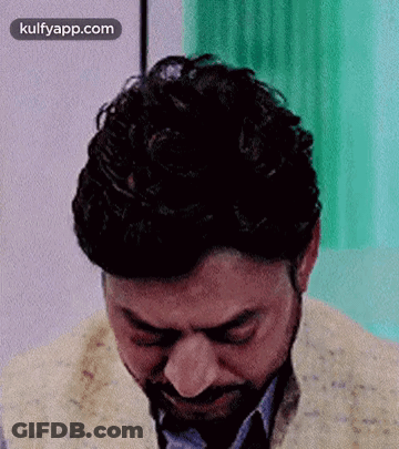 A Man With A Beard Is Crying With His Eyes Closed In A Room . GIF