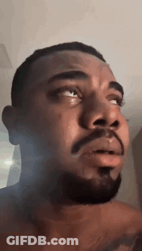 A Man With A Beard Is Crying With Tears Coming Out Of His Eyes . GIF