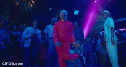 A Man With A Beard Is Dancing In A Club With A Group Of People . GIF