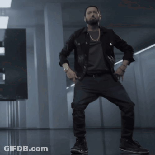A Man With A Beard Is Dancing In A Room GIF