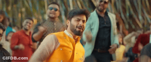 A Man With A Beard Is Dancing In Front Of A Crowd . GIF