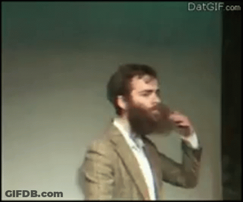 A Man With A Beard Is Drinking A Beer From A Glass . GIF