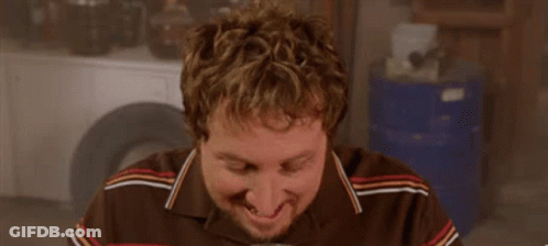 A Man With A Beard Is Drinking A Beer From A Mug . GIF