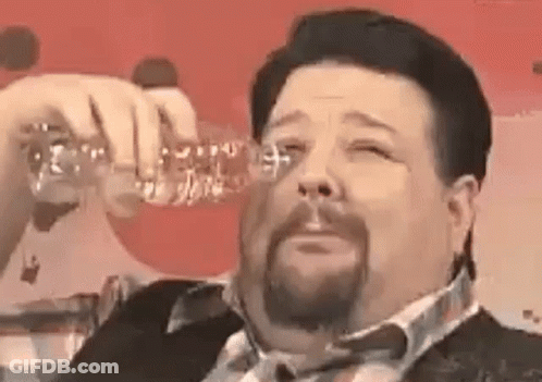 A Man With A Beard Is Drinking From A Bottle Of Water . GIF