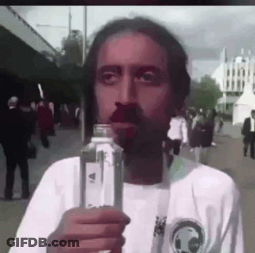A Man With A Beard Is Drinking From A Bottle Of Water . GIF