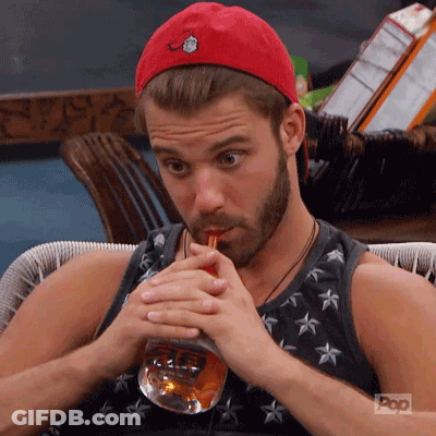 A Man With A Beard Is Drinking From A Glass Through A Straw . GIF