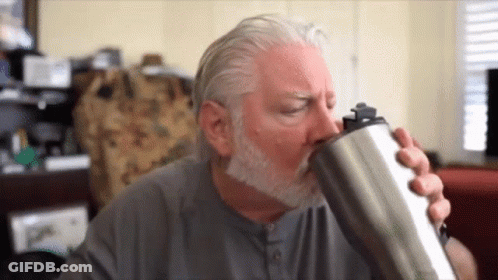 A Man With A Beard Is Drinking From A Stainless Steel Tumbler . GIF