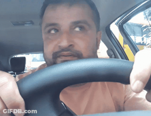A Man With A Beard Is Driving A Car With His Eyes Closed GIF