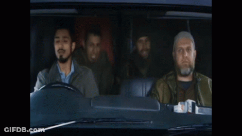 A Man With A Beard Is Driving A Car With Two Other Men Behind Him GIF