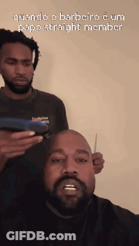 A Man With A Beard Is Getting His Hair Cut By Another Man With Dreadlocks GIF