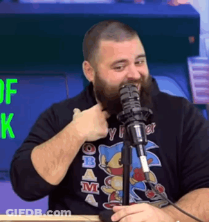A Man With A Beard Is Giving A Thumbs Up While Talking Into A Microphone . GIF