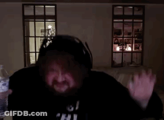 A Man With A Beard Is Giving An Ok Sign In Front Of A Christmas Tree . GIF