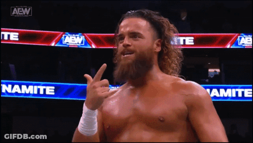 A Man With A Beard Is Giving The Middle Finger In Front Of A Sign That Says Namite GIF