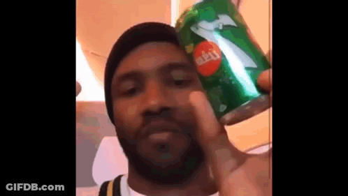A Man With A Beard Is Holding A Can Of Sprite . GIF