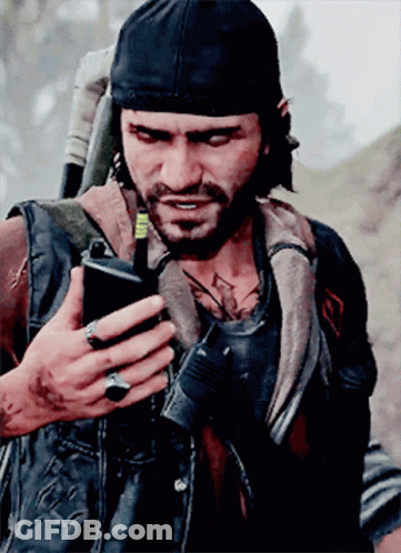 A Man With A Beard Is Holding A Cell Phone In His Hand GIF