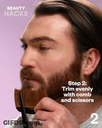 A Man With A Beard Is Holding A Comb And Scissors In His Hand GIF