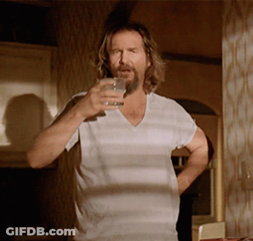 A Man With A Beard Is Holding A Glass Of Water GIF