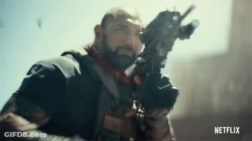 A Man With A Beard Is Holding A Gun In His Hand In A Netflix Trailer . GIF