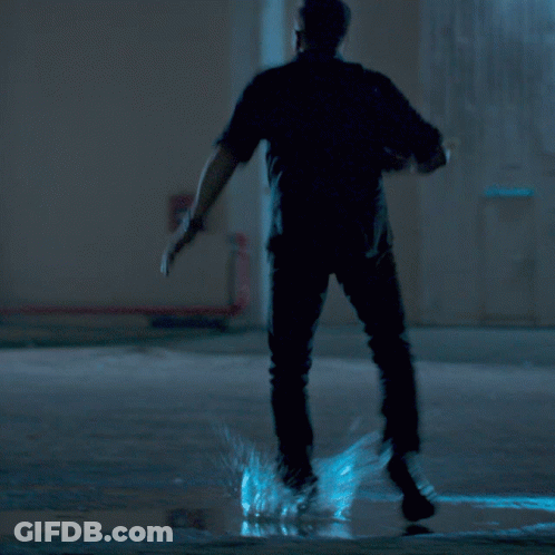 A Man With A Beard Is Holding A Gun In His Right Hand GIF