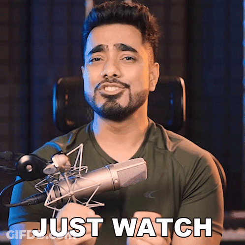 A Man With A Beard Is Holding A Microphone And Says " Just Watch " GIF