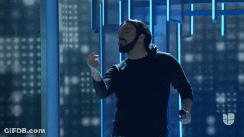 Man With Beard Holding Microphone In Front Of Window GIF