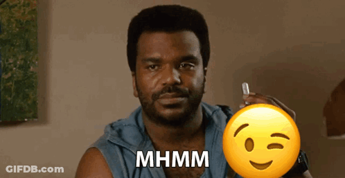 A Man With A Beard Is Holding A Pen And A Smiley Face With The Word Mhmm Written On It GIF