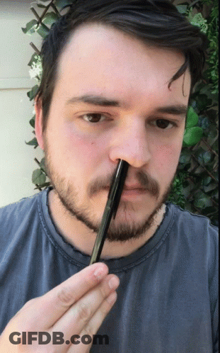 A Man With A Beard Is Holding A Pen In His Hand GIF