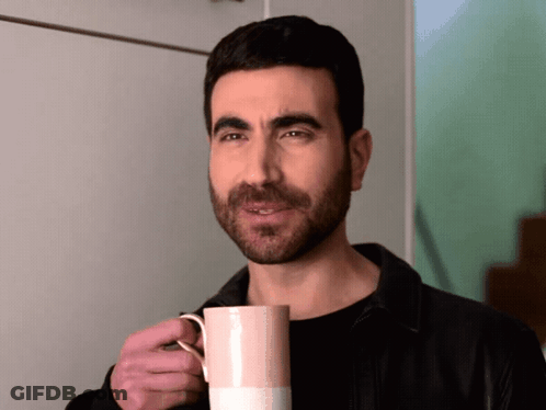 A Man With A Beard Is Holding A Pink Coffee Mug GIF