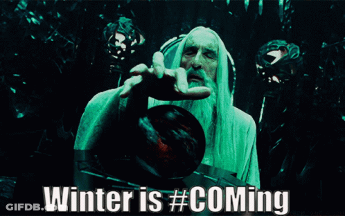 A Man With A Beard Is Holding A Red Ball With The Words Winter Is # Coming Below Him GIF