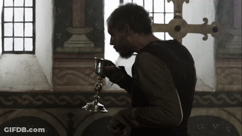 A Man With A Beard Is Holding A Small Silver Object GIF