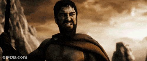 A Man With A Beard Is Holding A Spear In His Hand GIF