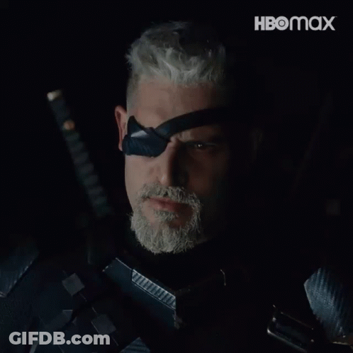 A Man With A Beard Is Holding A Sword And Wearing A Black Eye Patch With The Word Deathstroke On It GIF