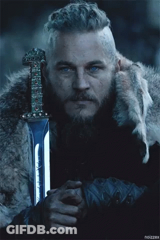 A Man With A Beard Is Holding A Sword In Front Of A Wolf GIF