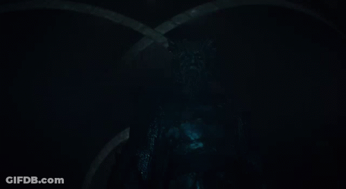 A Man With A Beard Is Holding A Sword In His Hand GIF