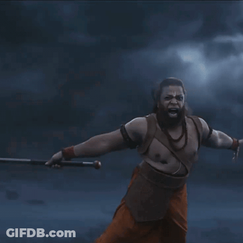 A Man With A Beard Is Holding A Sword In His Hands GIF