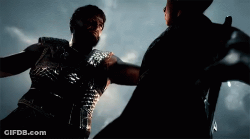 A Man With A Beard Is Holding Another Man 'S Arm GIF