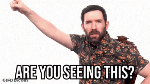 A Man With A Beard Is Holding His Fist Up And Says Are You Seeing This GIF