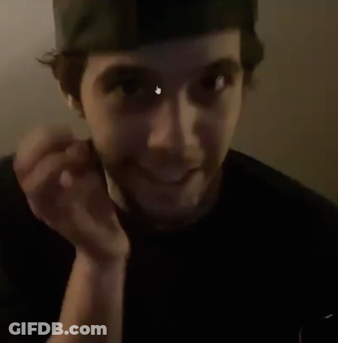 A Man With A Beard Is Holding His Hand To His Chin And Making A Face . GIF