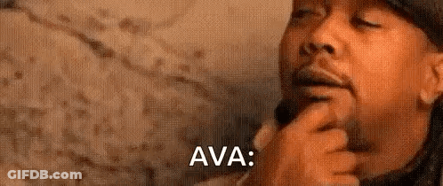 A Man With A Beard Is Holding His Hand To His Chin And Thinking . GIF