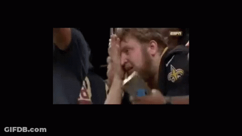 A Man With A Beard Is Holding His Nose While Watching A Game . GIF