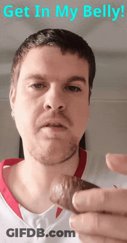 A Man With A Beard Is Holding Something In His Hand With The Words Get In My Belly Written Above Him GIF