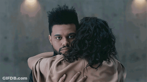 A Man With A Beard Is Hugging A Woman With Curly Hair .. GIF