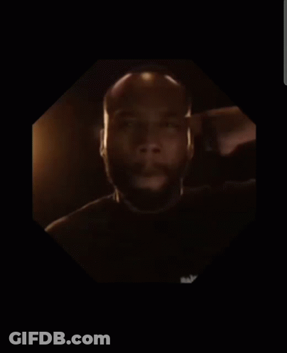 A Man With A Beard Is In A Dark Room GIF