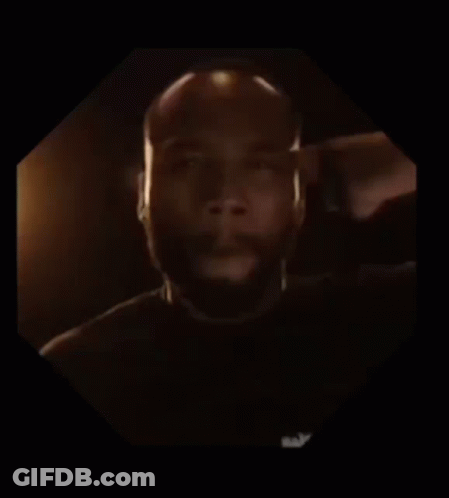 A Man With A Beard Is In A Dark Room GIF