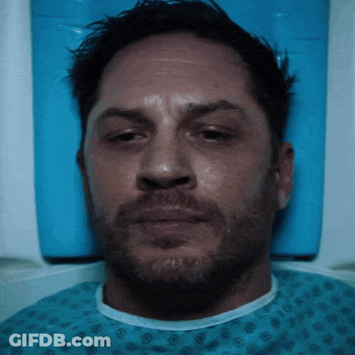 A Man With A Beard Is In A Hospital Gown GIF