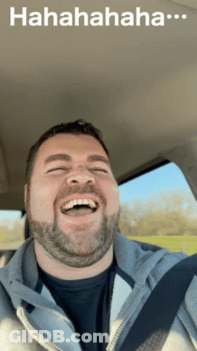 A Man With A Beard Is Laughing In A Car With A Caption That Says " Hahahahaha " GIF
