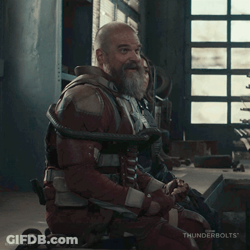 A Man With A Beard Is Laughing While Sitting In A Wheelchair GIF