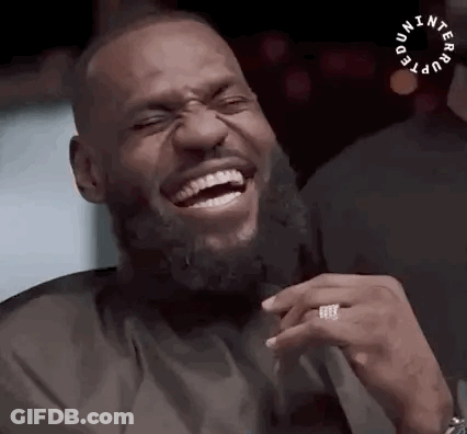 A Man With A Beard Is Laughing With His Eyes Closed And A Ring On His Finger . GIF