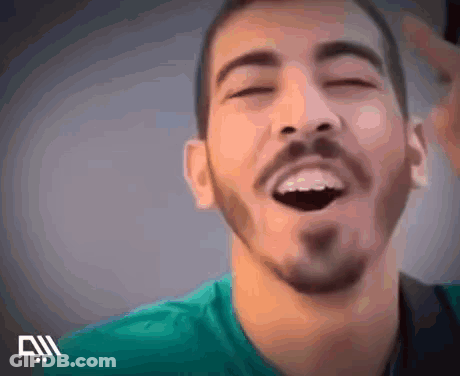 A Man With A Beard Is Laughing With His Eyes Closed . GIF